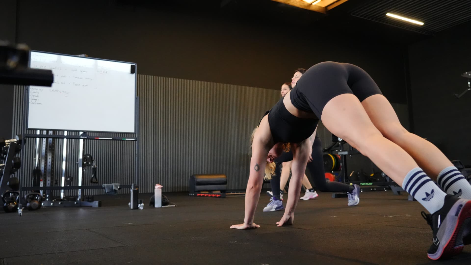Lid traint kracht onder begeleiding op de trainingsvloer van Composure Gym