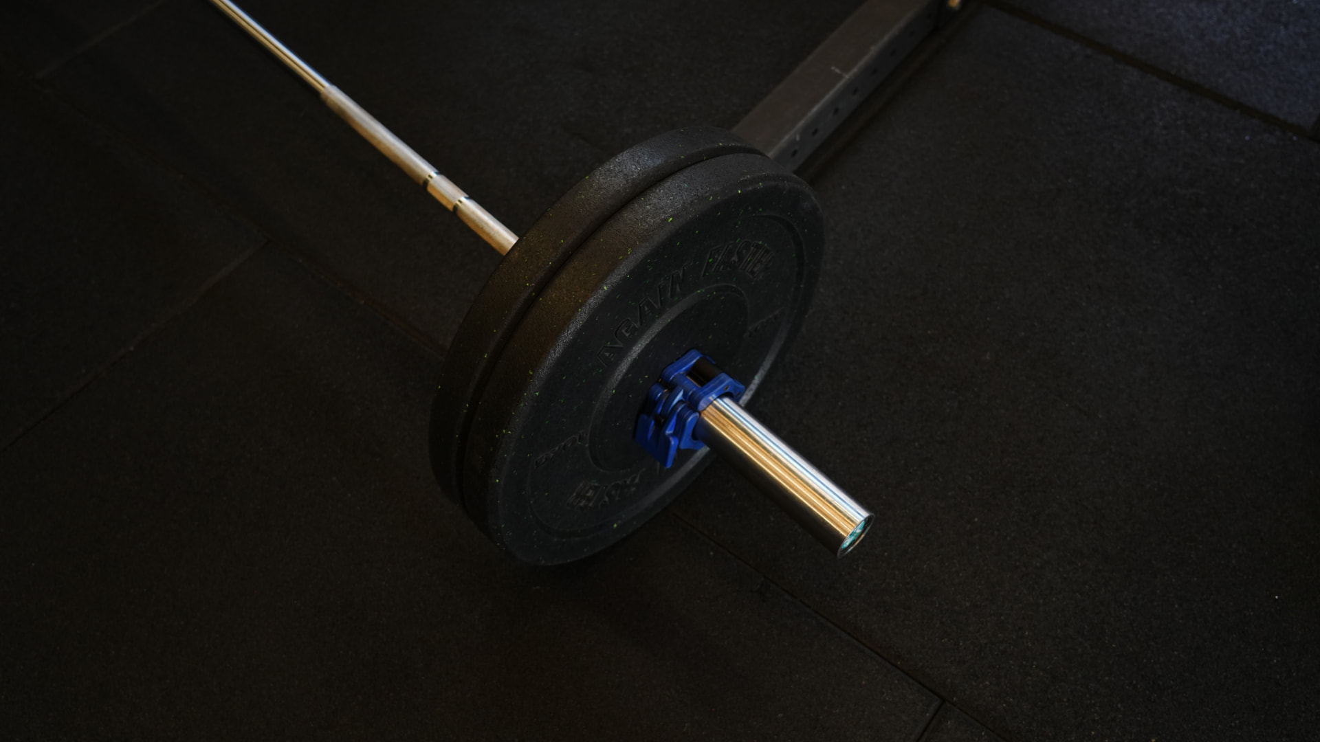 Detailfoto van een barbell met schijven op de rubberen vloer